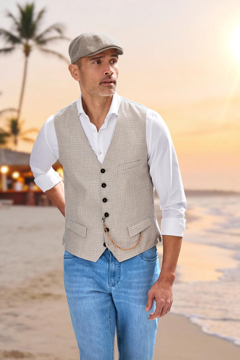 Lichtbeige linnen vest van Carl Gross met knopen op het strand.