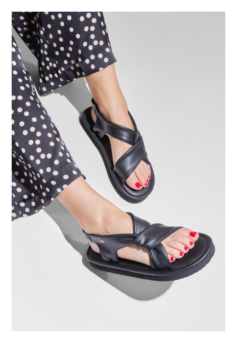 Voeten van een vrouw in zwarte flip-flop ultralight sandalen met nagellak