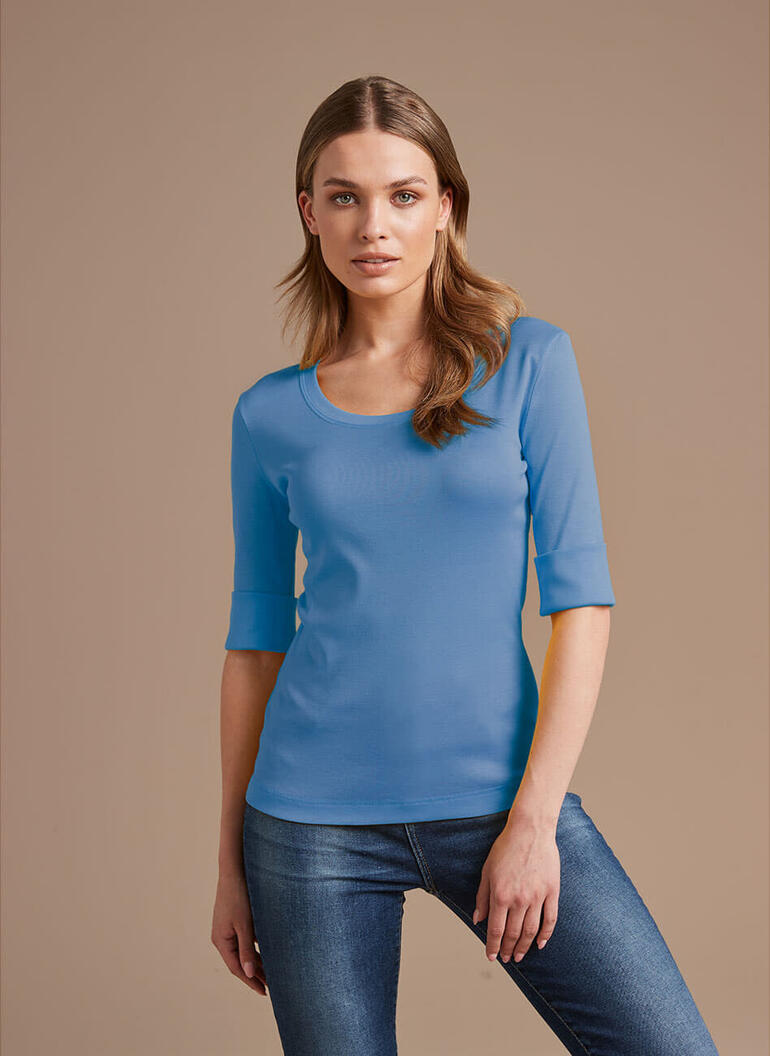 Blauw Wolff-shirt, vrouwelijke model op neutrale achtergrond.