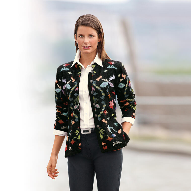 zwart/multikleurig Alpaca cardigan flowers, gedragen door een vrouw met een onscherpe achtergrond.