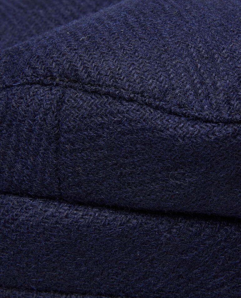 Close-up van donkerblauwe cashmere stof met geweven structuur.