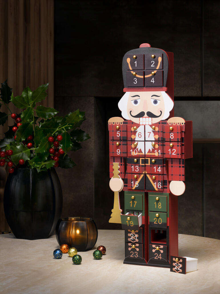 Adventskalender in de vorm van een notenkraker, versierd met genummerde deurtjes.