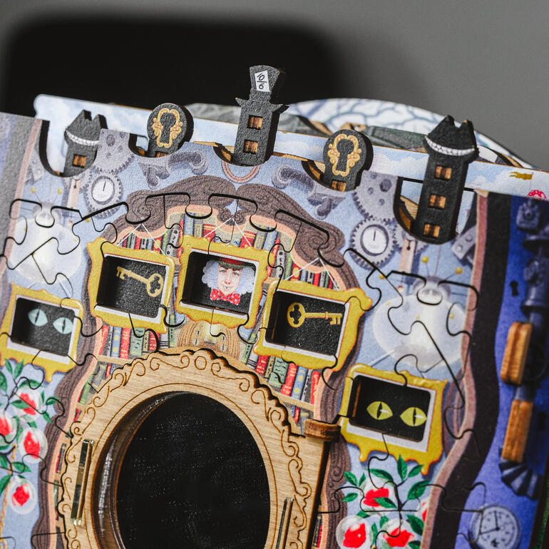 Detailopname van de Wonderbox met puzzelstukjes en een sleutel.