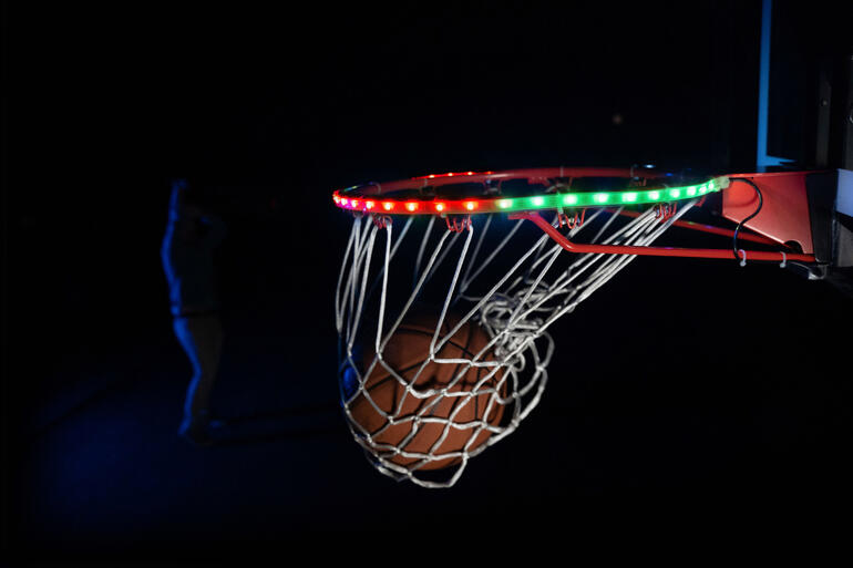 Close-up van de basket met LED-verlichting en een bal in de buurt.