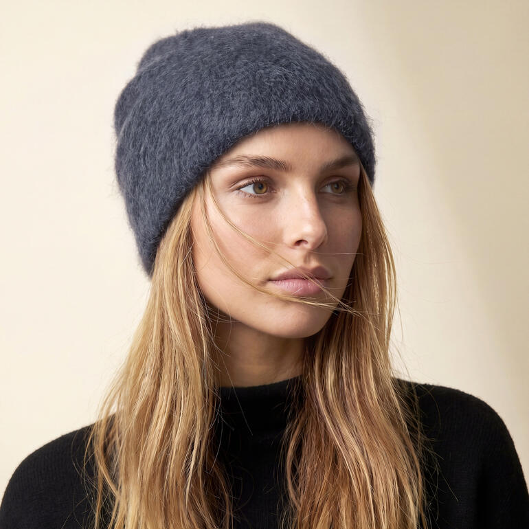 Vrouw met grijze cashmere muts in natuurlijk licht