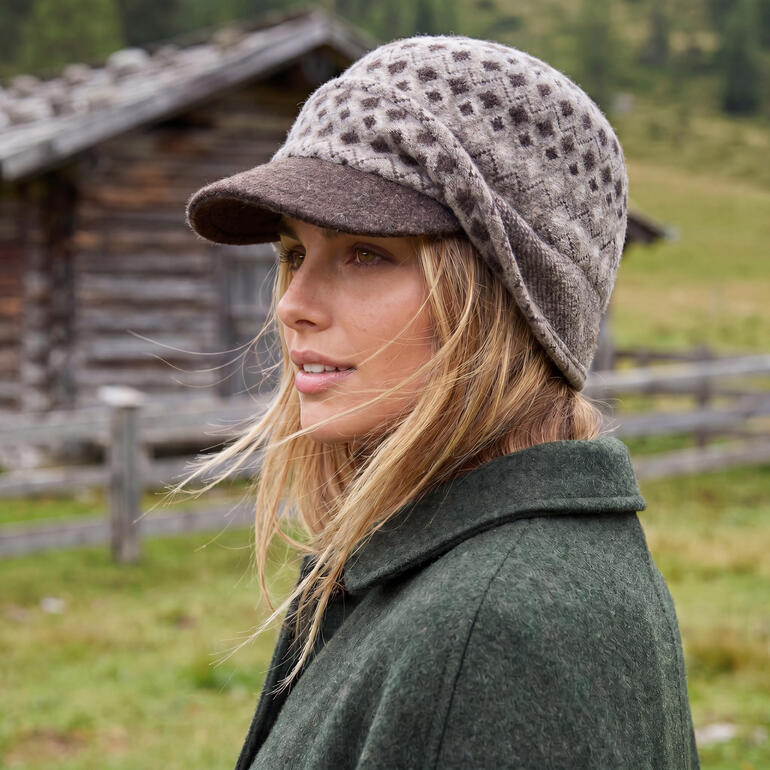 Vrouw met bruine jacquard oorwarmer op haar hoofd