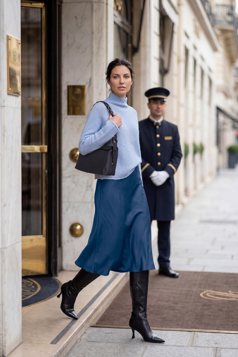 Vrouw in Junghans 1954 boxy trui verlaat een hotel