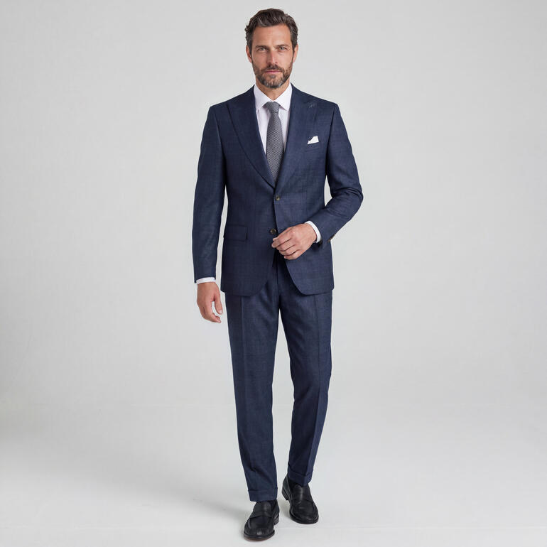 Man draagt een donkerblauwe flanellen blazer met bijpassende broek