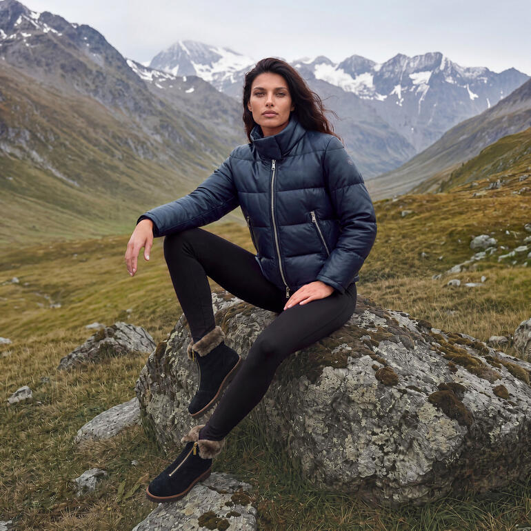 Vrouw in donkerblauwe winterjacke en zwarte leggings in berglandschap