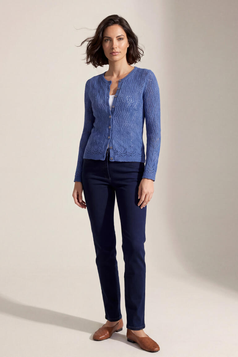 Vrouw in een paarse Eribe Lace-Stitch cardigan en donkere broek.
