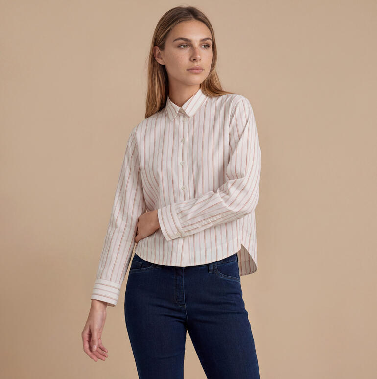 Vrouw in een gestreepte blouse met kraag.