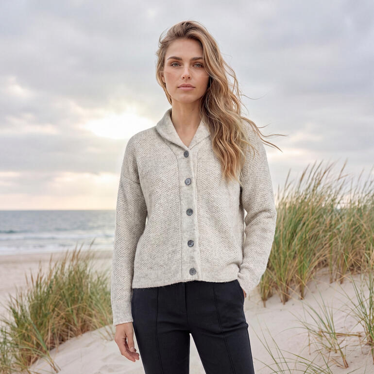 Vrouw in beige Fisherman geluk cardigan op het strand met de zee