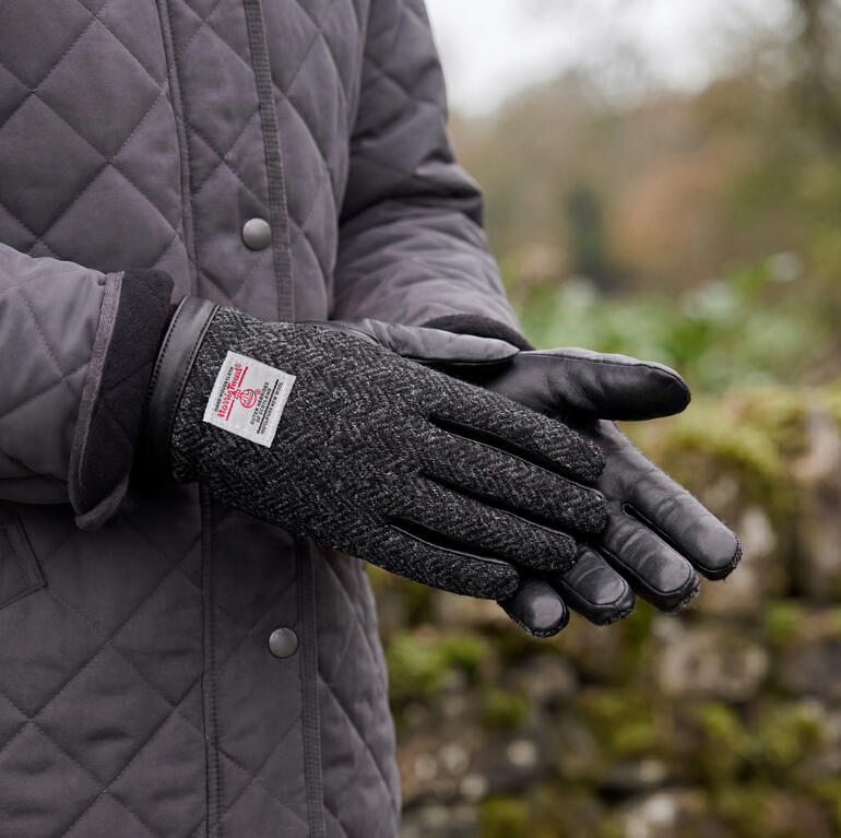 Zwarte Harris Tweed handschoenen zijn in een close-up te zien.