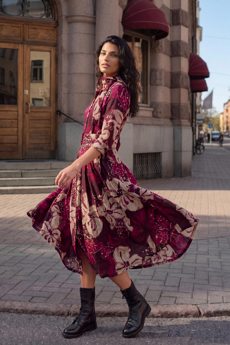 Vrouw in Berry-Flower wollen jurk draait zich op straat